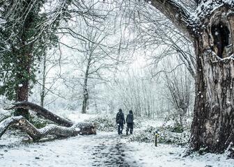 Twee mensen wandelen in het sneeuwlandschap.