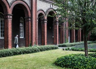 Wandelende man loopt door de zuilengalerij op het binnenplein van het museum. 