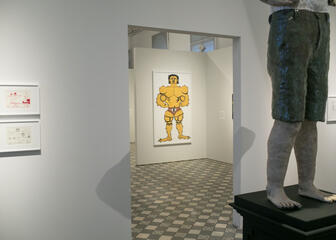 Een momentopname in de tentoonstellingsruimte: een deel van een standbeeld  en een schilderij worden getoond.