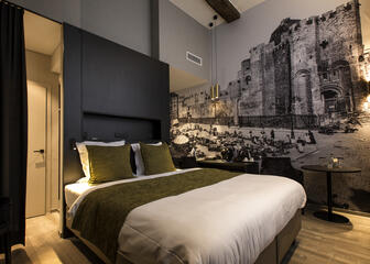 hotelkamer met tweepersoonsbed en muurfoto van het gravensteen