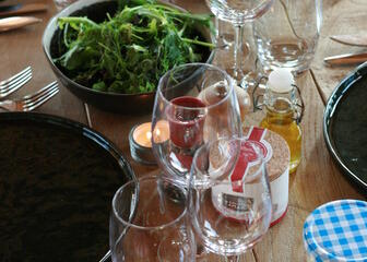 close-up gedekte tafel met glazen, borden, een kom sla,…