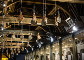 plafond vleeshuis, verschillende hammen die ophangen aan houten balken