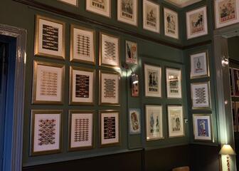 binnenkant café romain met houten tafels en stoelen, de muren hangen vol met oude foto's 