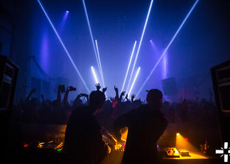 DJ-draaitafel voor feestende massa in het industriële fabrieksgebouw van Kompass Club
