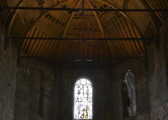 Interior de la capilla con una vista de las cerchas del techo