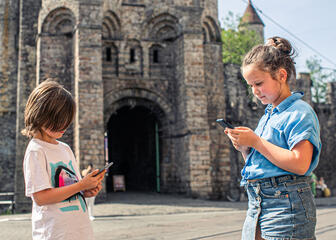 Zwei Kinder mit Smartphones im Schloss der Grafen
