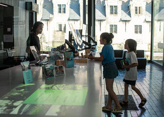 Zwei Kinder, die Informationen im Tourismusbüro von Gent anfordern