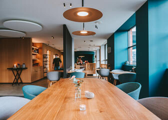 Skandinavisches Interieur mit Holztischen und hellblauen Sitzen