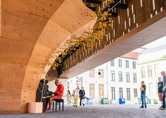 Man speelt op de piano onder de stadshal