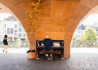 Un homme joue du piano sous la Halle municipale