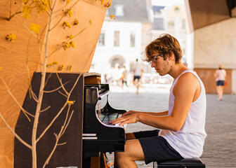 Man speelt op de piano onder de stadshal