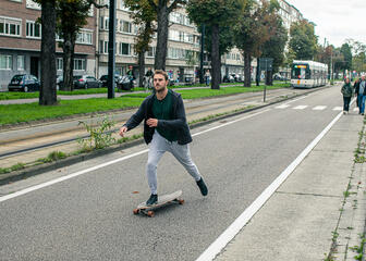 Un homme sur un skateboard dans la rue pendant le dimanche sans voiture.