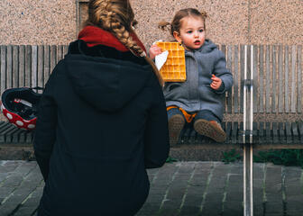 Mama en kindje op een bank met wafel in de hand