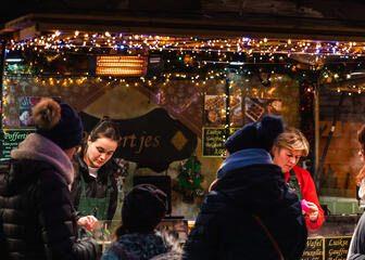Menschen an einem Marktstand auf dem Weihnachtsmarkt