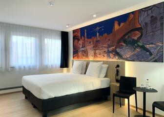 Room with double bed, wooden headboard and painting of Moebius 