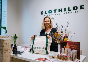 Chloé posing with a handbag by Clothilde at the reception desk 