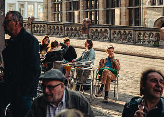 Several people enjoy a drink in the sunny weather