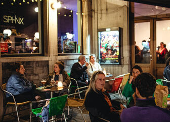Mehrere Personen genießen einen abendlichen Drink auf einer überdachten Terrasse