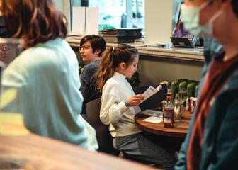 Mädchen liest ein Buch an einem Tisch