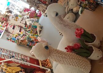 2 white stuffed animals with plush flower pots 