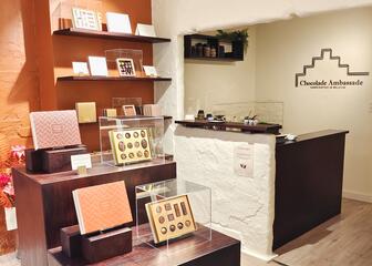 The interior of the shop with several open gold gift boxes with chocolates 