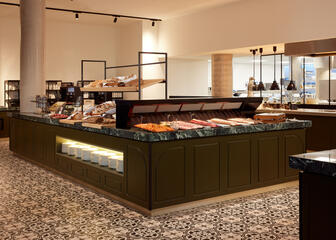 large buffet table in the middle with toppings, pastries and bread 