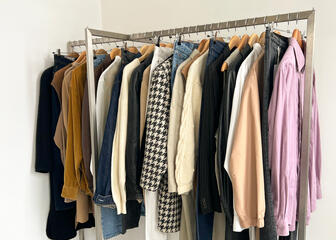 clothes rack with clothes in front of a white wall 