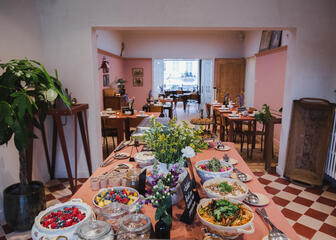 Mesa buffet con flores, varios platos y macetas