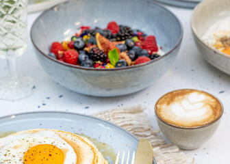 Pfannkuchen mit Ei und Speck. Kaffee. Obstsalat