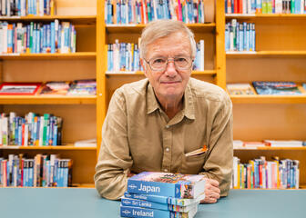 Tony Wheeler met verschillende Lonely Planet boeken in Gent