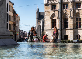 Tiany und Familie am Brunnen am Sint-Baafsplein in Gent an einem sonnigen Tag