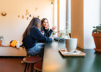 Tiany Kiriloff and her daughter enjoy a coffee in front of the window of a cozy coffee bar in Ghent
