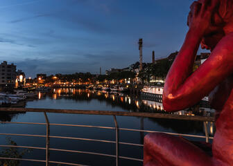 Rote Statue einer Dame am Wasser des Yachthafens Portus Ganda in Gent