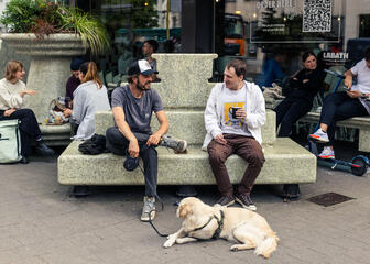Two young men enjoy a coffee at Bar Labath with their dog
