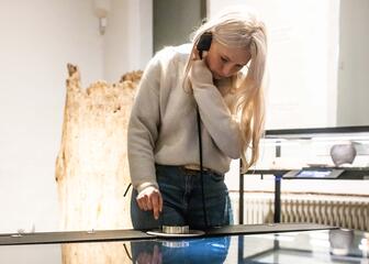Sarah hört sich den Audioguide an, der die Geschichte von Gent im STAM-Museum in Gent erzählt