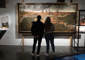 Sarah et son petit ami regardent un tableau qui aide à raconter l’histoire de Gand dans le STAM