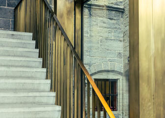 Concrete staircase with brass handrail shows visitors the way in St Bavo Cathedral's new visitor centre