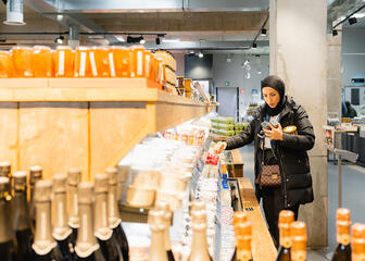 Fatina Daher bekijkt producten in een indoor foodhal in Gent
