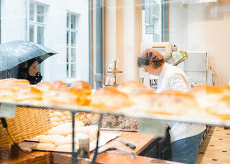 Fatina looks at all the goodies in the display case of a bakery in Ghent