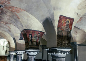 Romaanse donkerrode fresco's op de zuilen van de crypte in de Sint-Baafskathedraal