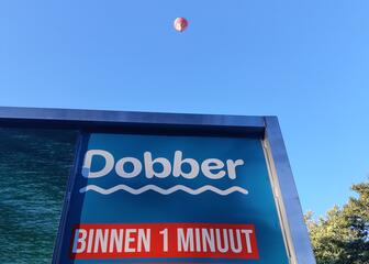 Dobber station en een zwevende rode luchtballon op de achtergrond