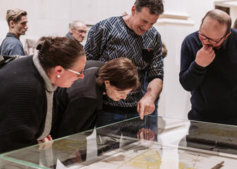 Museum visitors admire objects in a showcase