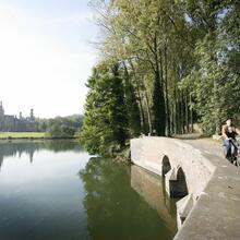 fietsers langs een rivier  met in de verte een kasteel 