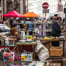 Brocantemarkt bij Sint-Jacobs met op de voorgrond kraam met porselein en bric-à-brac.
