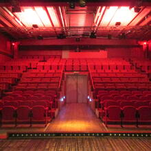 auditorium met rode verlichting en rode klapstoelen
