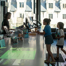 Twee kinderen die informatie vragen in het toerismekantoor van Gent