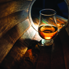Glas mit Whisky in einem Faß