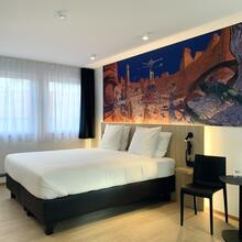 Chambre avec lit double, tête de lit en bois et une peinture de Moebius 
