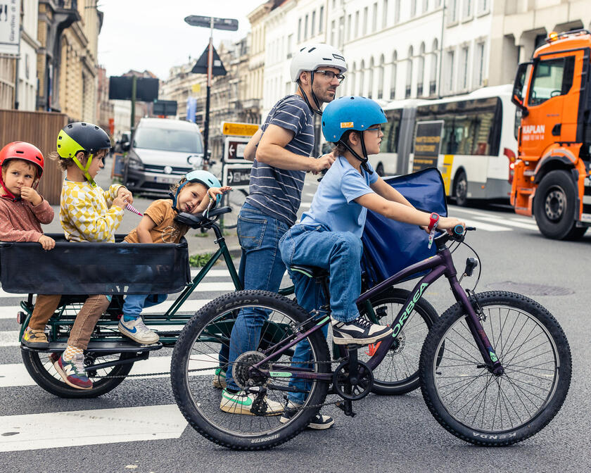 Vader fietst met longtailfiets met zijn gezin door de straten van Gent