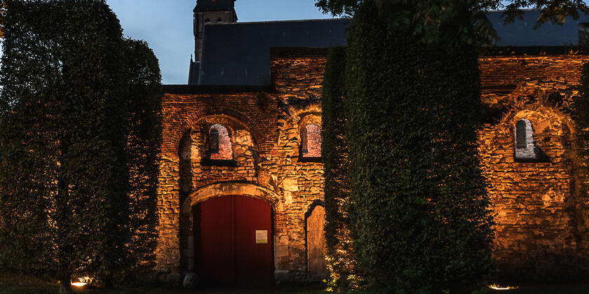 Ruinas bellamente iluminadas de la Abadía de San Bavón en Gante al atardecer